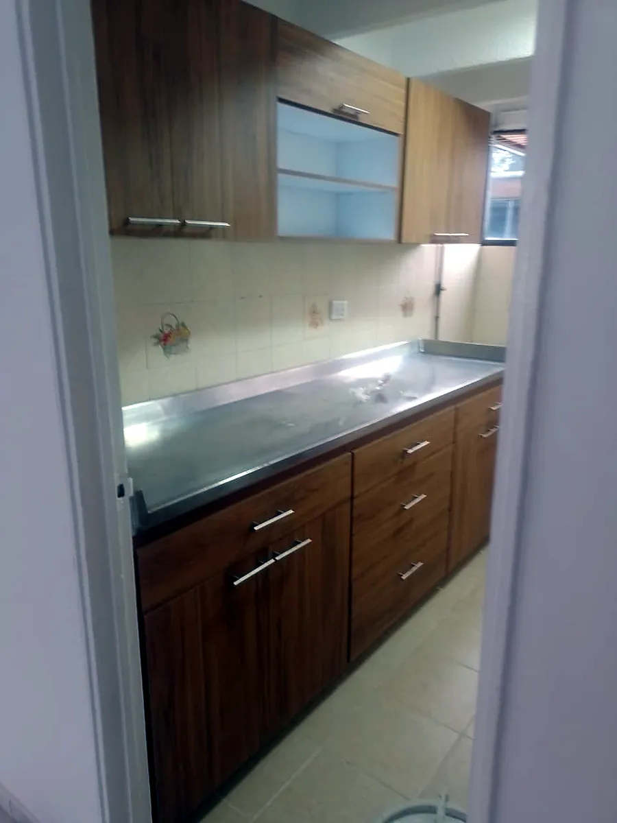 Cocina integral en madera con mesón de acero