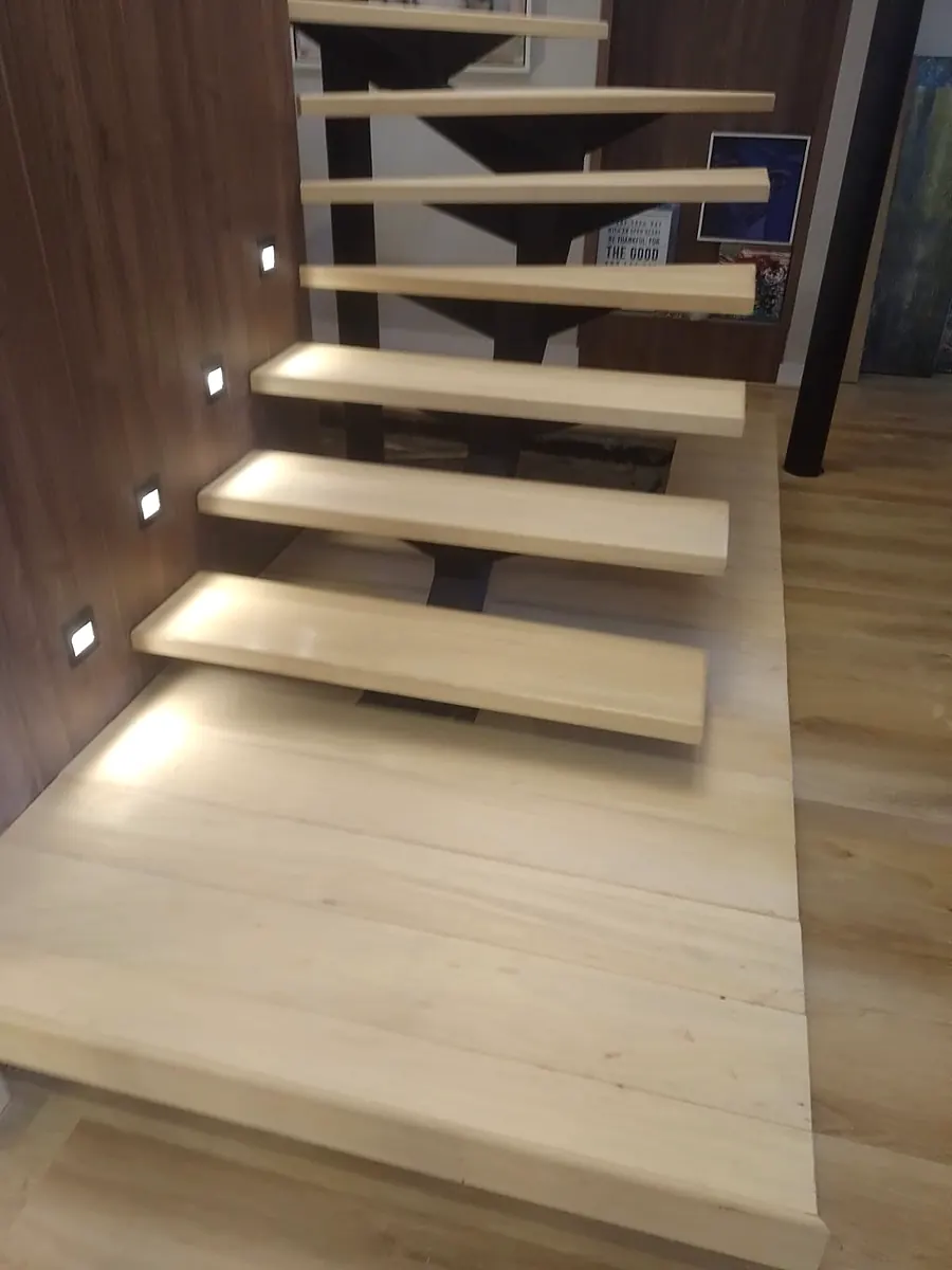 Escalera flotante con peldaños de madera e iluminación